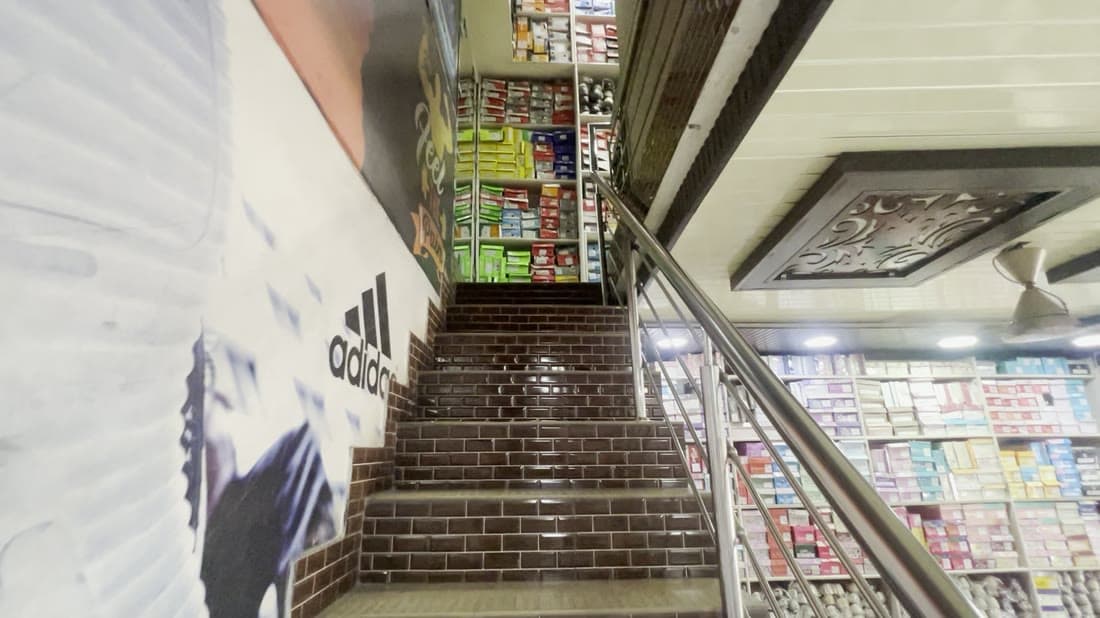 Climbing the staircase between floors, both sides lined with boxes