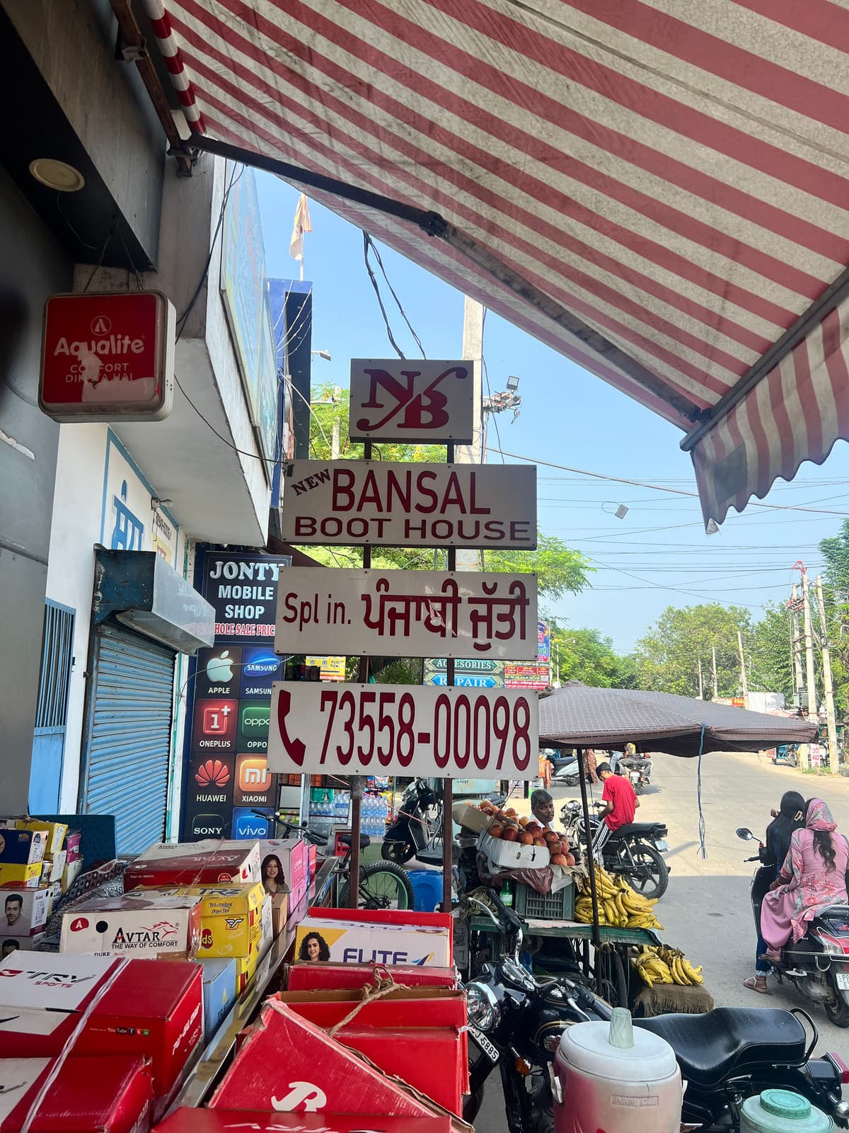 The street signboard reading New Bansal Boot House and ਪੰਜਾਬੀ ਜੁੱਤੀ